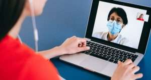 pessoa com um notebook aberto e tendo uma consulta online com uma médica do Clude